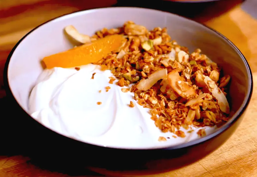 Granola tibia de avellanas con yogur, una opción de desayuno saludable y satisfactoria, perfecta para una comida matutina nutritiva.